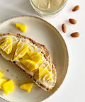 Brot mit Lemke Stadtstreicher Mandel, Mandelcreme im Glas und Mandeln auf einem Teller