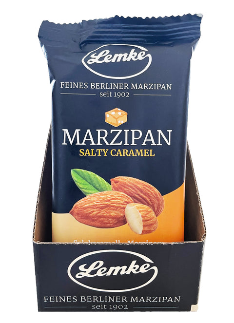 Eine Display-Schale mit 14 Packungen Lemke Salty Caramel Marzipan (je 200g), wobei nur die erste Packung sichtbar ist. Die Verpackung ist überwiegend schwarz mit dem Lemke-Logo, dem Schriftzug "Feines Berliner Marzipan seit 1902" und einem Bild von Mandeln und Salzkaramell.
